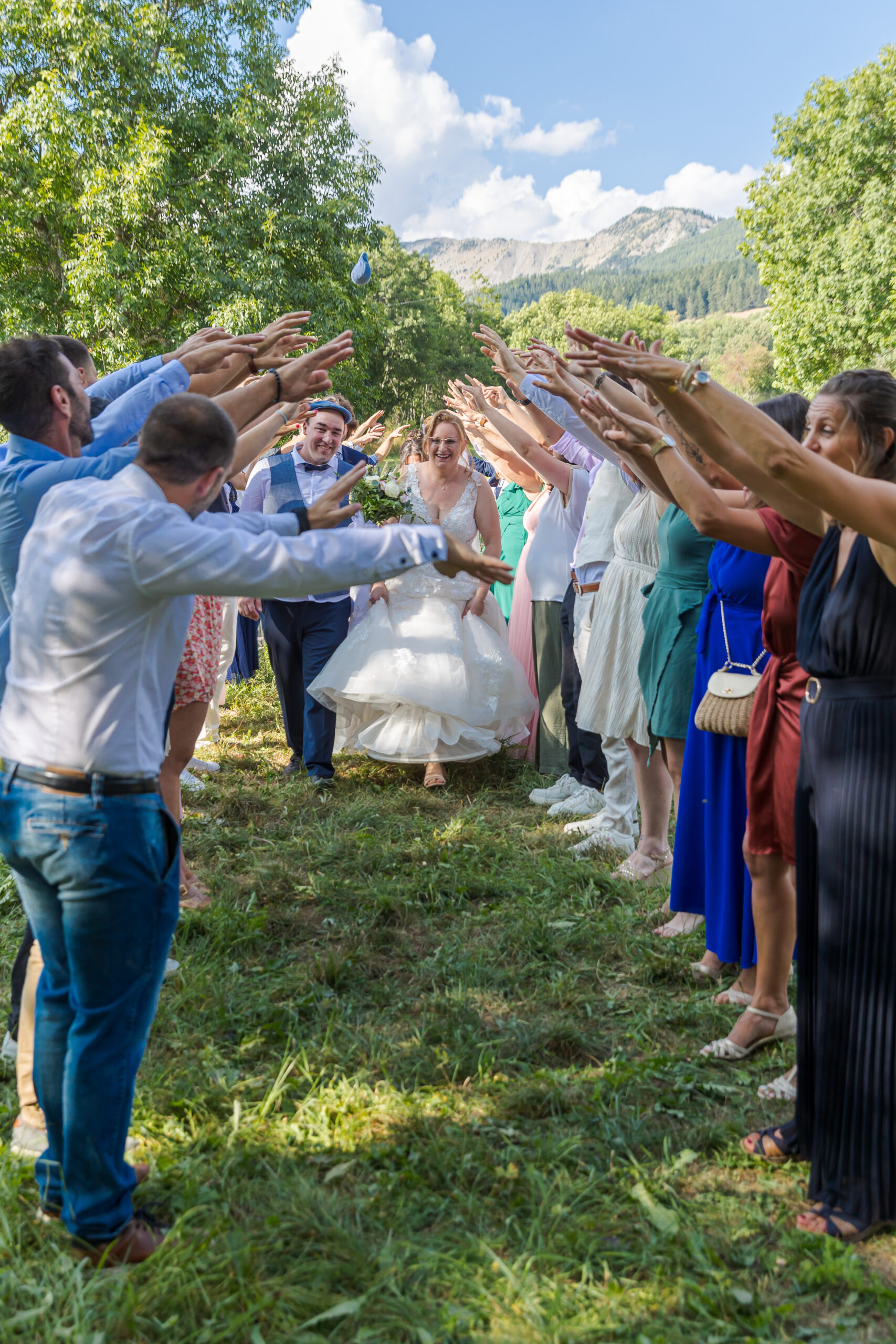 Sortie des mariés sous une haie d’honneur formée par les invités, ambiance festive et joyeuse – M.Studiophoto13