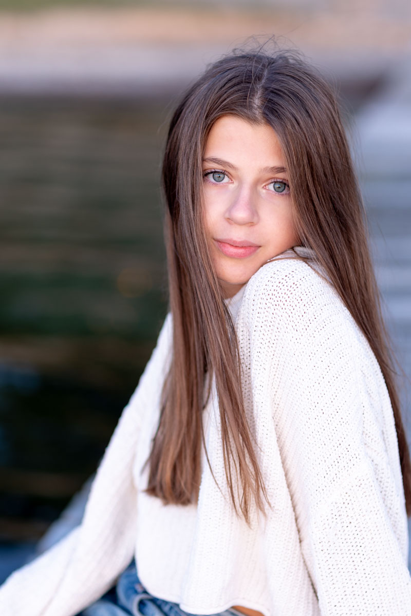 Instants Naturels - Photographie en lumière Naturelle à Aix en Provence et Marseille 1 Jeune fille aux cheveux lisses et grands yeux bleus, vêtue d'un pull blanc et d'un jean, illuminée par un magnifique coucher de soleil