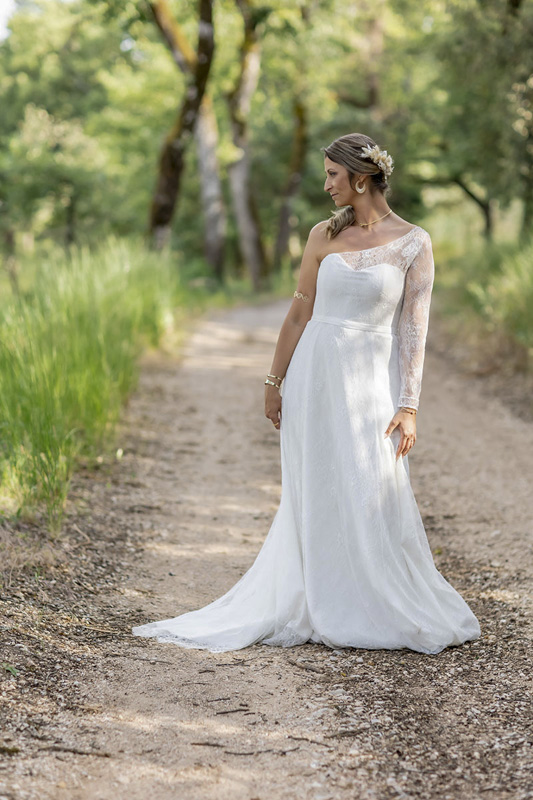 Mariée en robe blanche posant dans un chemin boisé, photo de mariage naturelle par M.Studiophoto13