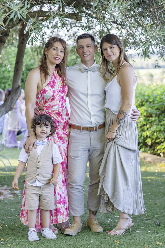 Photo de famille et invités souriants lors d’un mariage en extérieur – par M.Studiophoto13