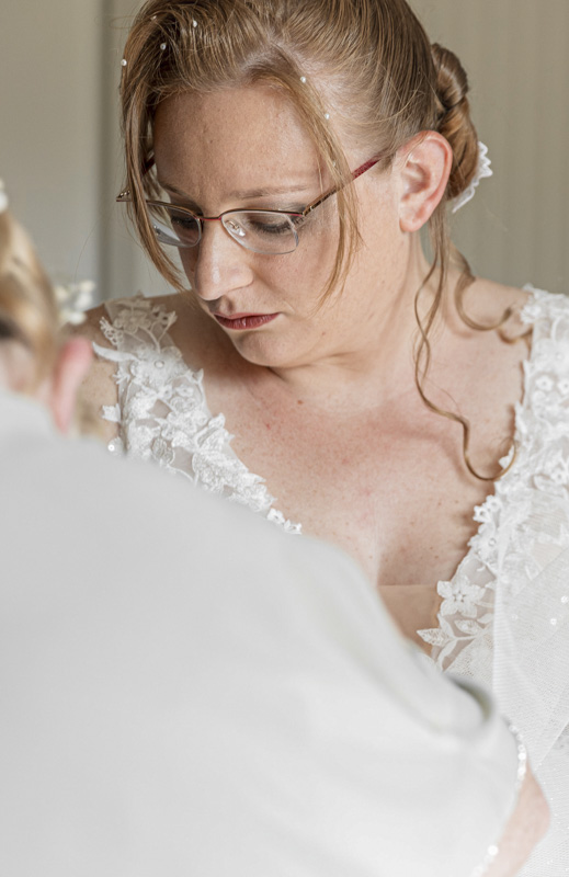 Mariée en robe blanche ajustant son collier – préparatifs de mariage par M.Studiophoto13