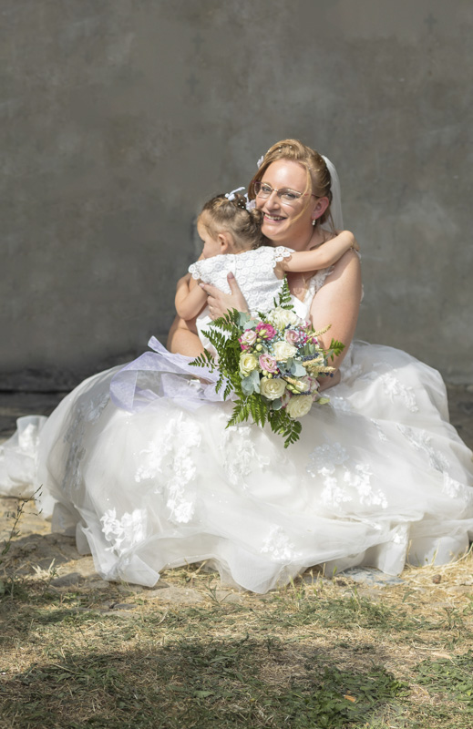 Mariée souriante tenant son bouquet, sous une pluie de confettis à la sortie de la cérémonie – M.Studiophoto13