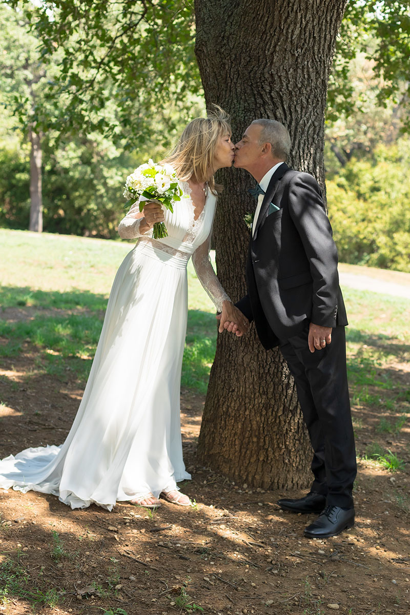 Mariés s’embrassant tendrement sous un arbre lors de leur séance photo de mariage – photographie par M.Studiophoto13