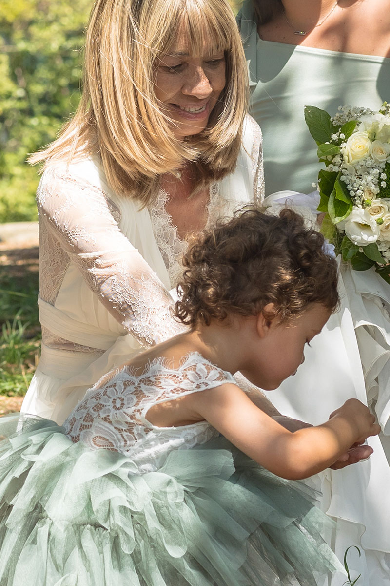 Moment complice entre une femme et une petite fille en robe de cérémonie lors d’un mariage – photographie par M.Studiophoto13