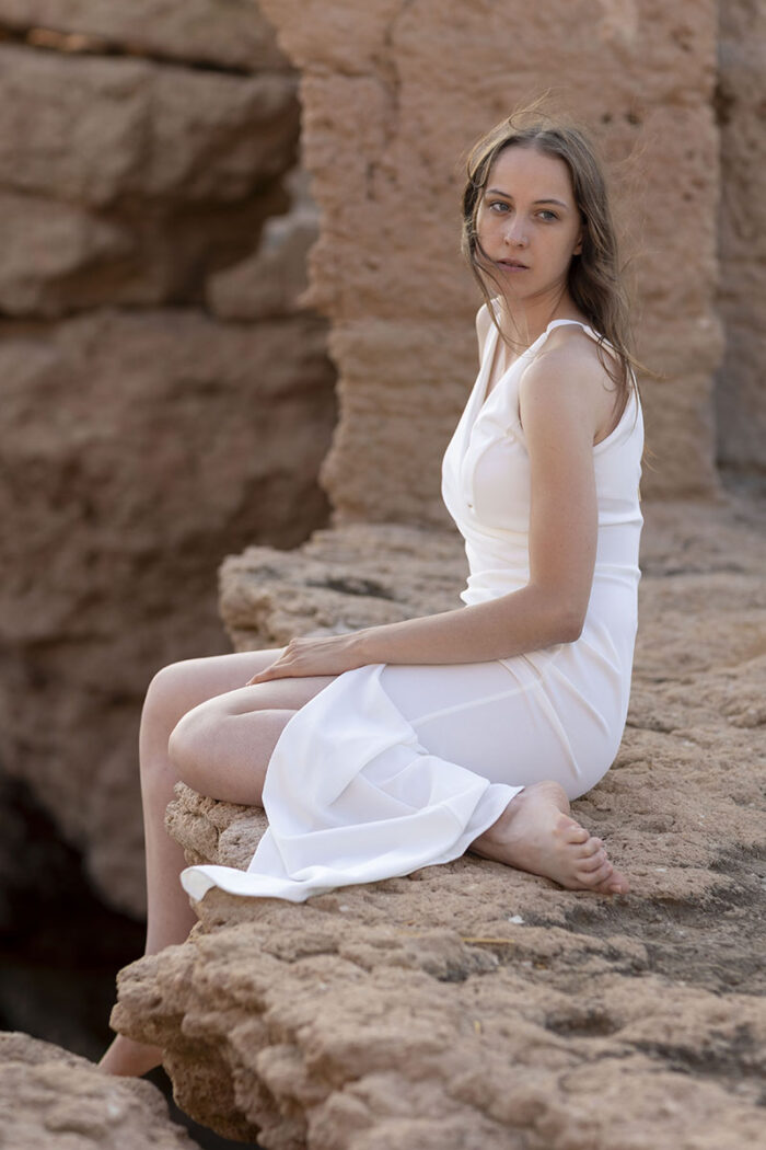 ☺☺femme en robe blanche assise sur la roche face à la mer