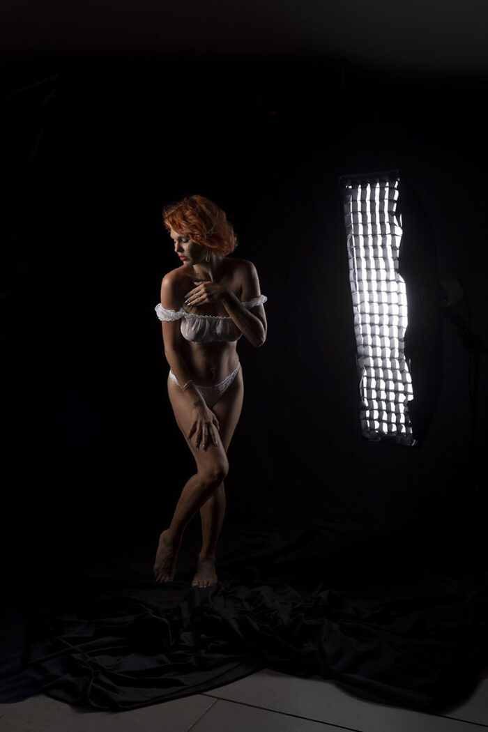 Portrait boudoir en studio sur fond noir, pose élégante avec lumière directionnelle – photographe aux Pennes-Mirabeau