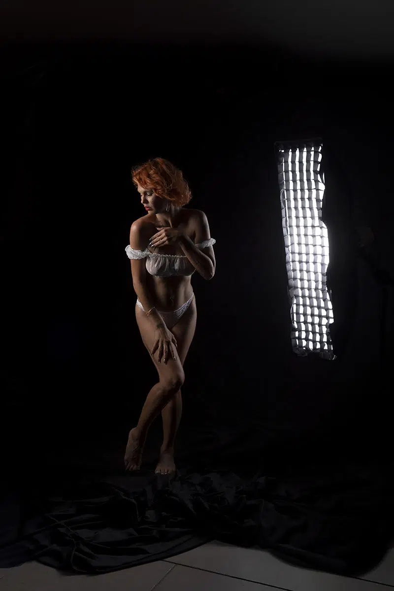 Portrait boudoir en studio sur fond noir, pose élégante avec lumière directionnelle – photographe aux Pennes-Mirabeau